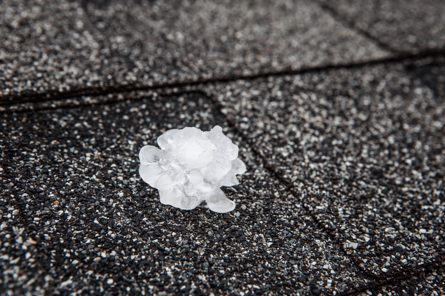 An illustration depicting the impact of hail on roofs, showing various roofing materials affected by hail damage. 