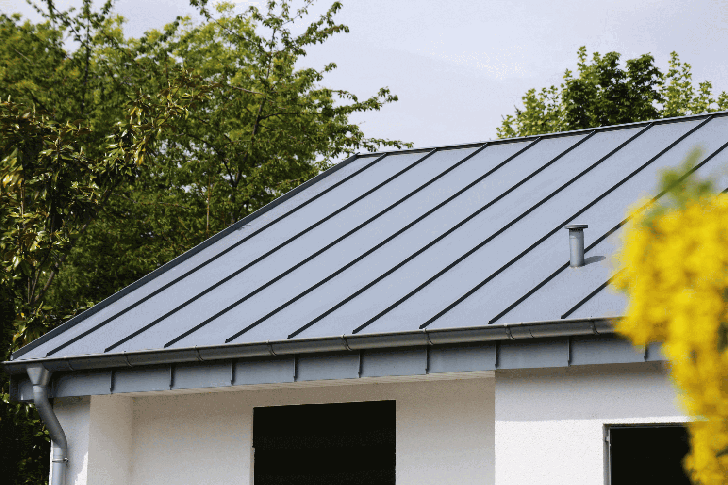 A worker installing a metal roof ridge cap.