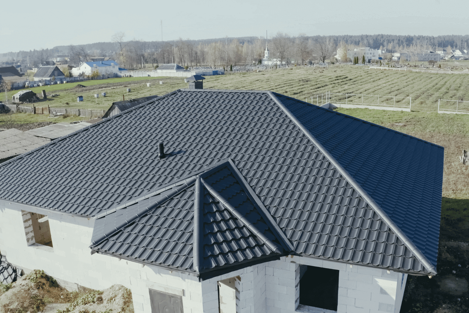 Vented ridge caps being installed on a metal roof.