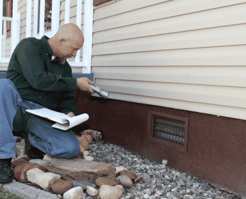 A professional foundation inspector examining a home's foundation.